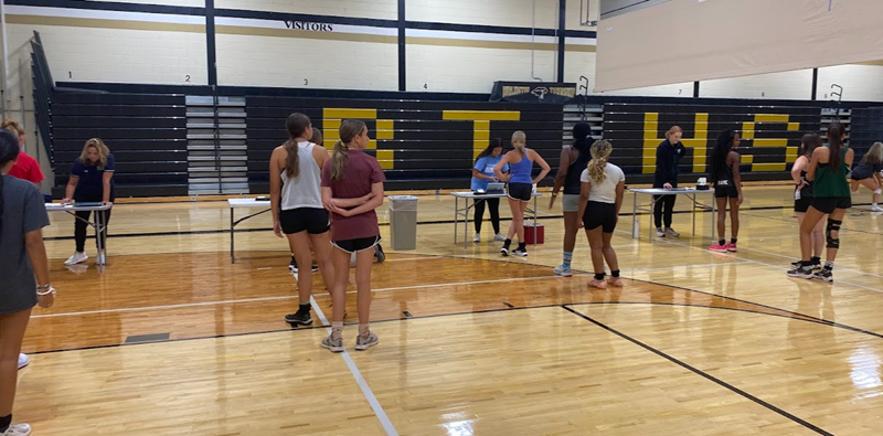Basketball players in a gym setting preparing for agility training drills that focus on quick direction changes, balance, and reaction speed.