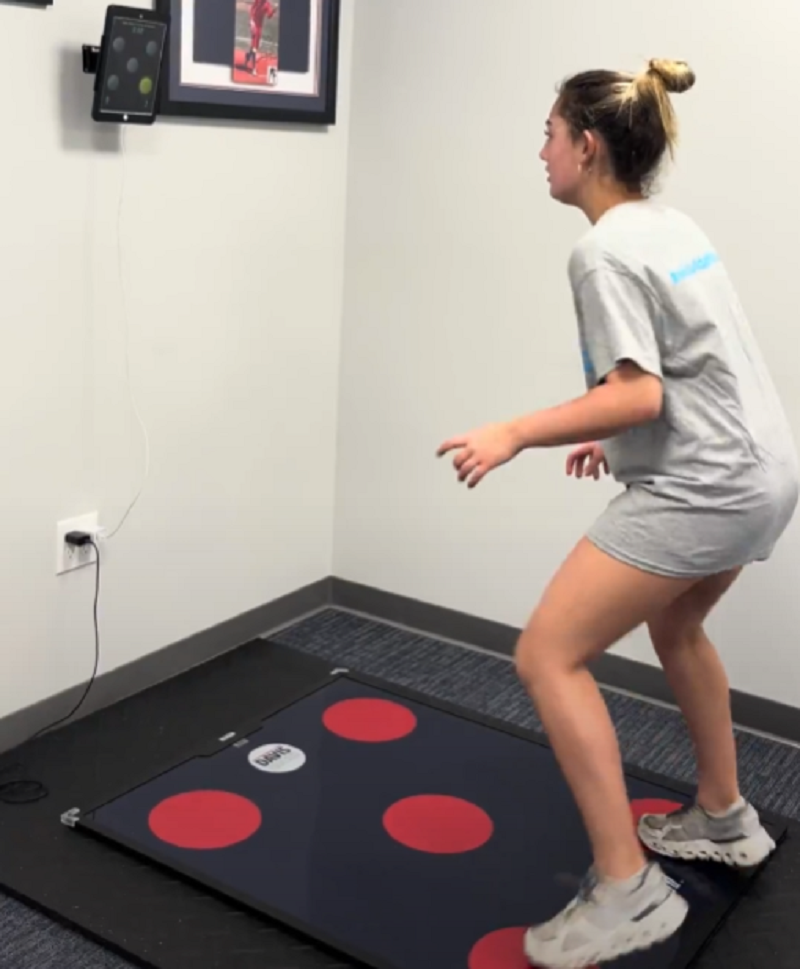 Athlete performing Quick Board footwork drills while reacting to visual cue patterns on a screen, training faster defensive decisions and angle adjustments.