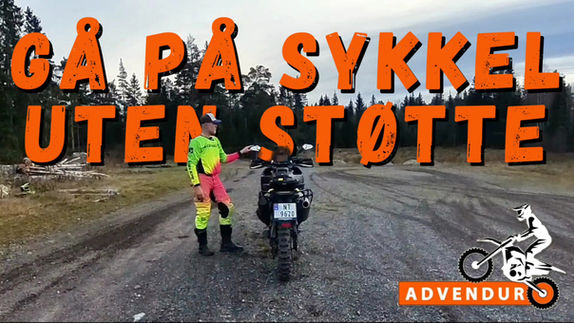 en erfaren motorsyklist står ved siden av sin motorsykkel, han lærer folt hvordan de kan gå av og på motorsykkel uten fotstøtte