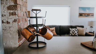 copper mugs hanging from stand
