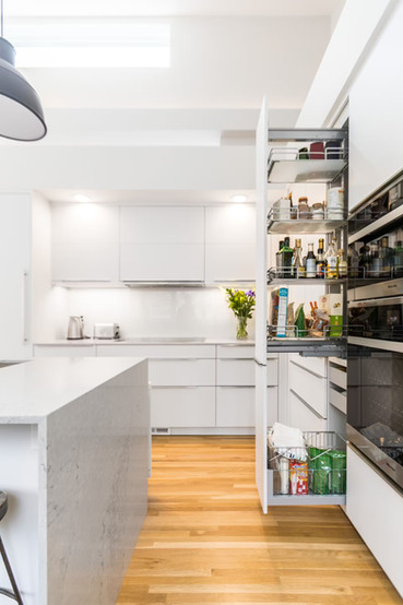 Efficient kitchen cabinet organization featuring stackable containers and dividers.