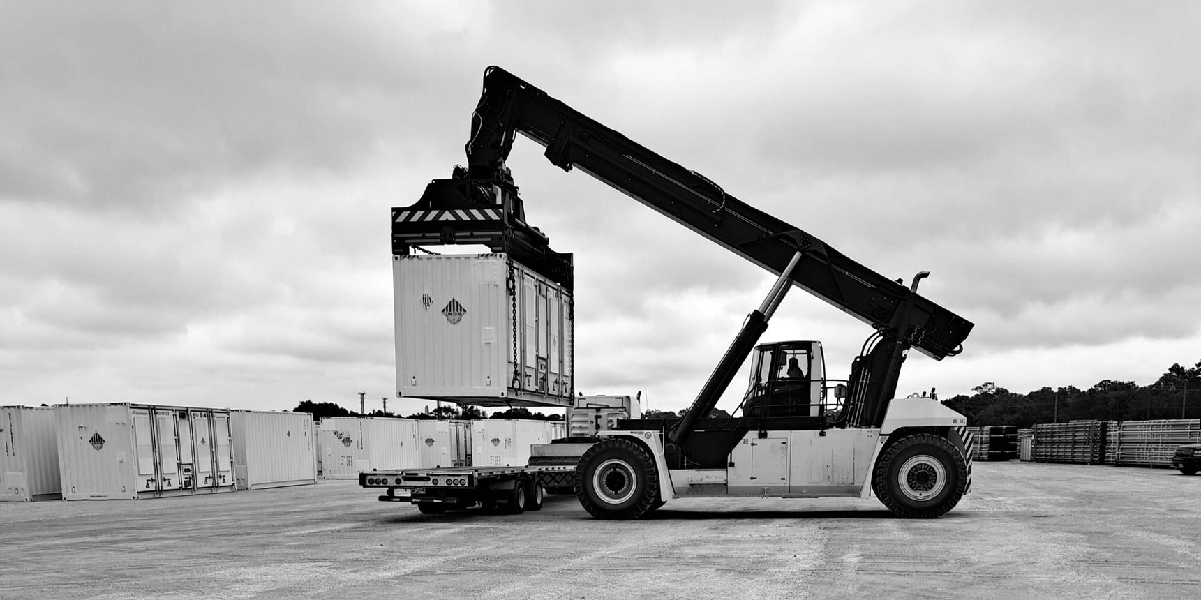 BESS unit being transported by a top loader in a storage yard
