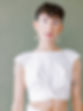 LGBTQ male wearing oversized pearl drop earrings and croped wedding twopiece top