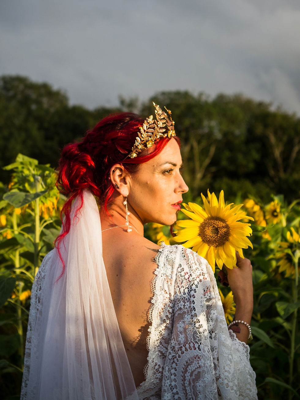 bride wearing a crown, with low bun hairstyle. embroidered veil is place underneath the bun