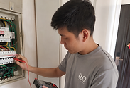 Electrician checking power socket and wiring in Singapore home