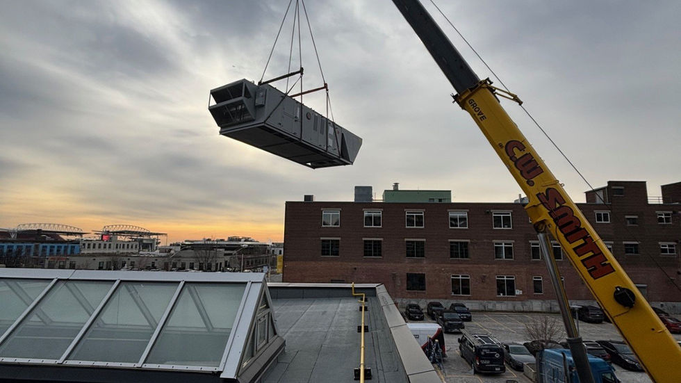 Large rooftop air-handling unit set by mobile crane on a heritage brick building (photo 5)