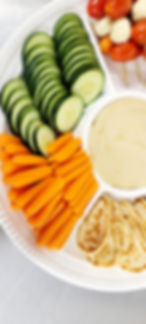 Veggie platter with baby carrots, sliced cucumber and hummus dip.