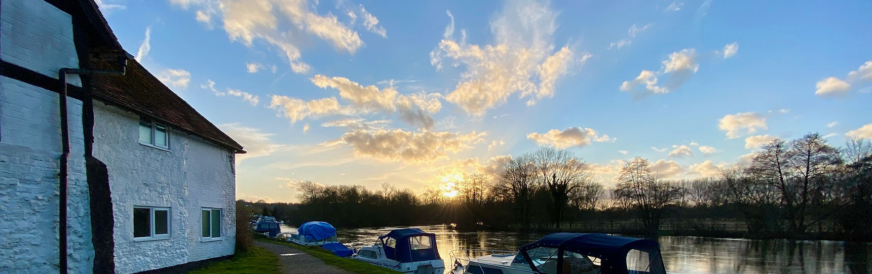 A country cottage by the river Thames at sunset