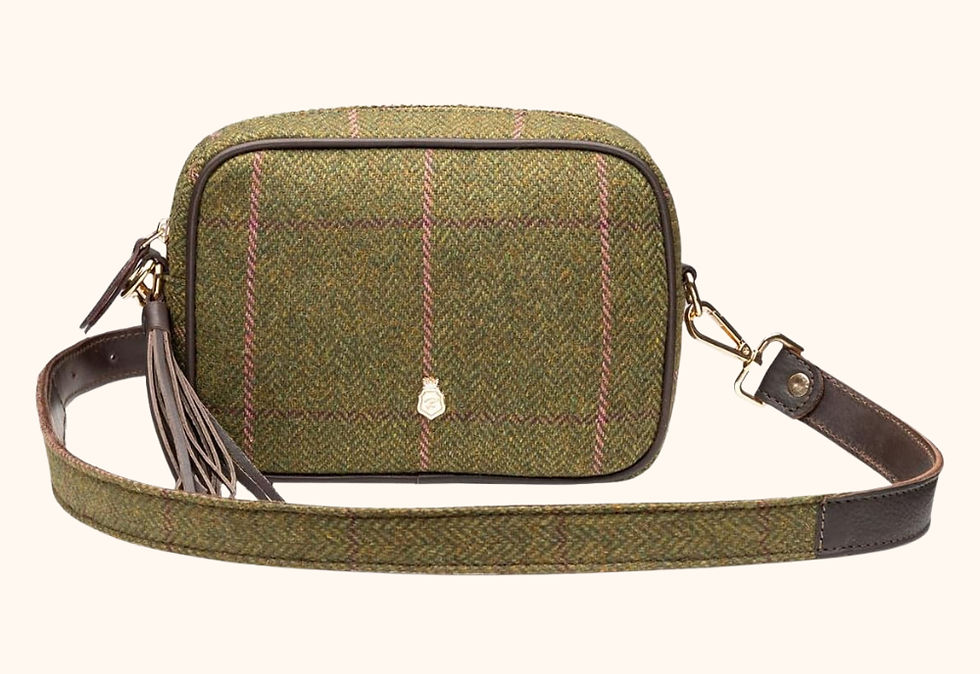 Green tweed crossbody bag with a plaid pattern, brown leather strap, and tassel. Neutral background, small gold badge on front.