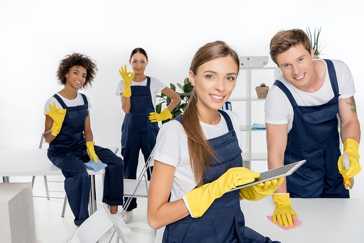 smiling-young-female-cleaner-using-digital-tablet-while-colleagues-working-behind.jpeg