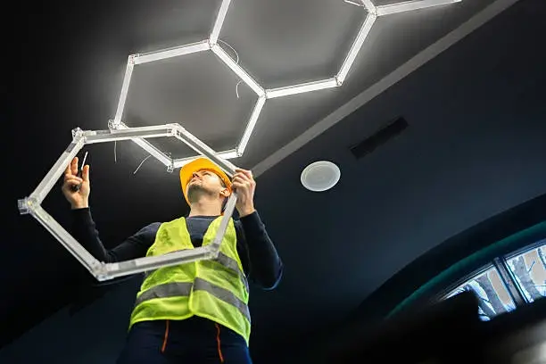 electrician-installing-modern-hexagon-led-lighting-system.webp