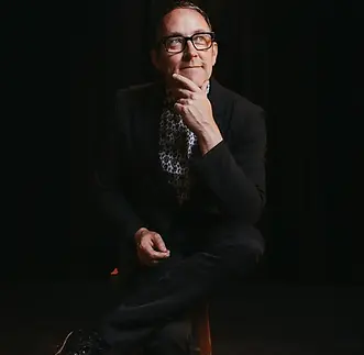 Corporate Vancouver Magician and Mentalist Bro Gilbert sitting on chair looking up