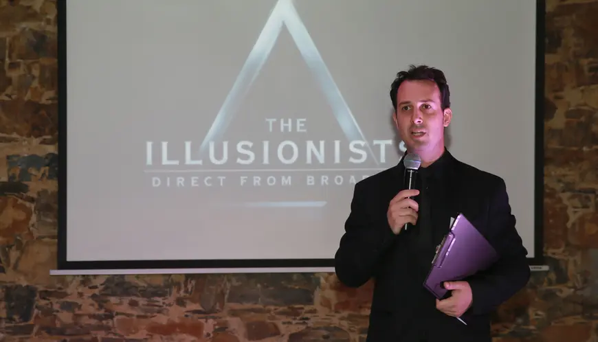 Mentalist Bryan Miles holding microphone as Master of Cermonies at a coprorate event.