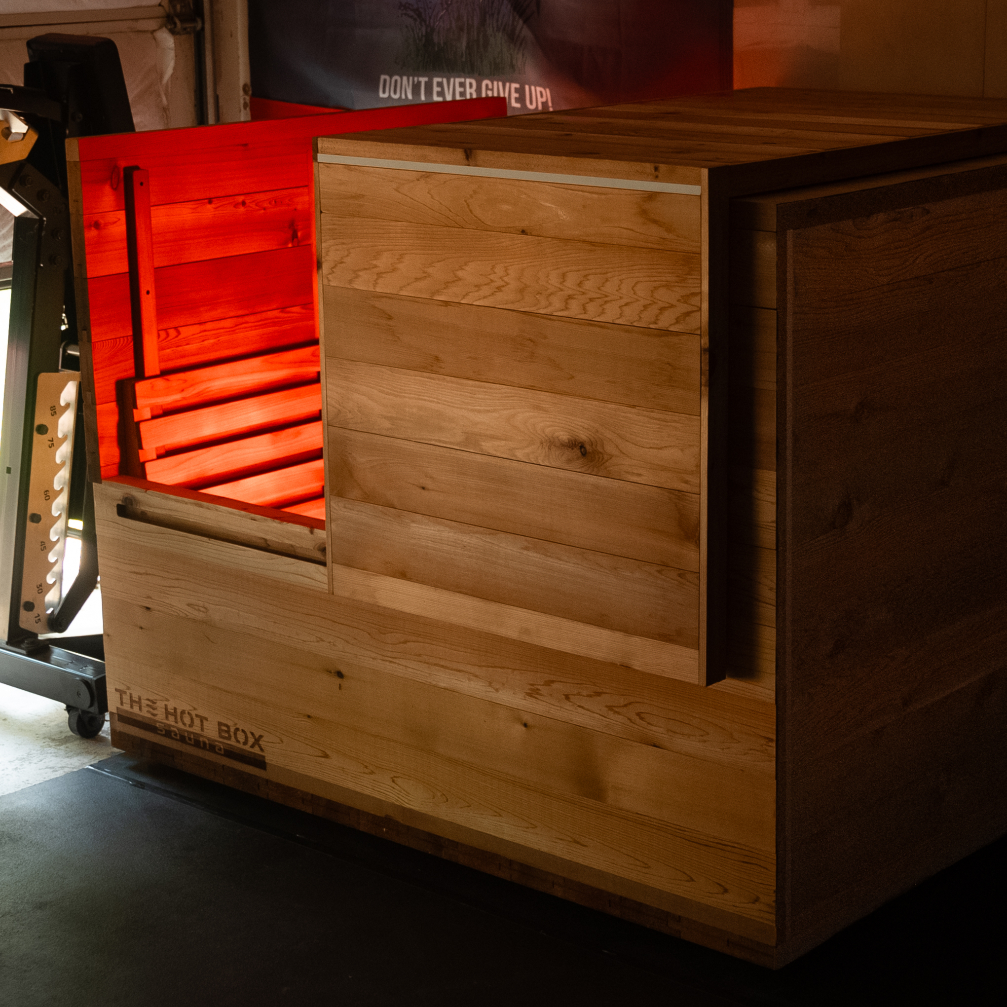 The Hot Box Sauna XL with red light glowing from inside the cabin