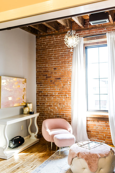 Elegant pink chair in exposed brick room