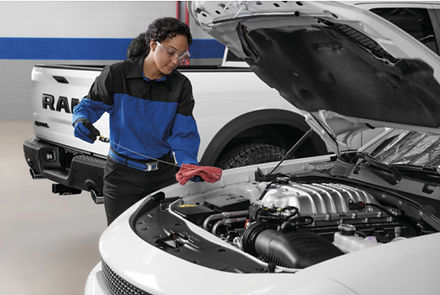 Certified service technician checking engine oil level during routine maintenance