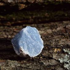 Rough angelite aka anhydrite on cracked wood.
