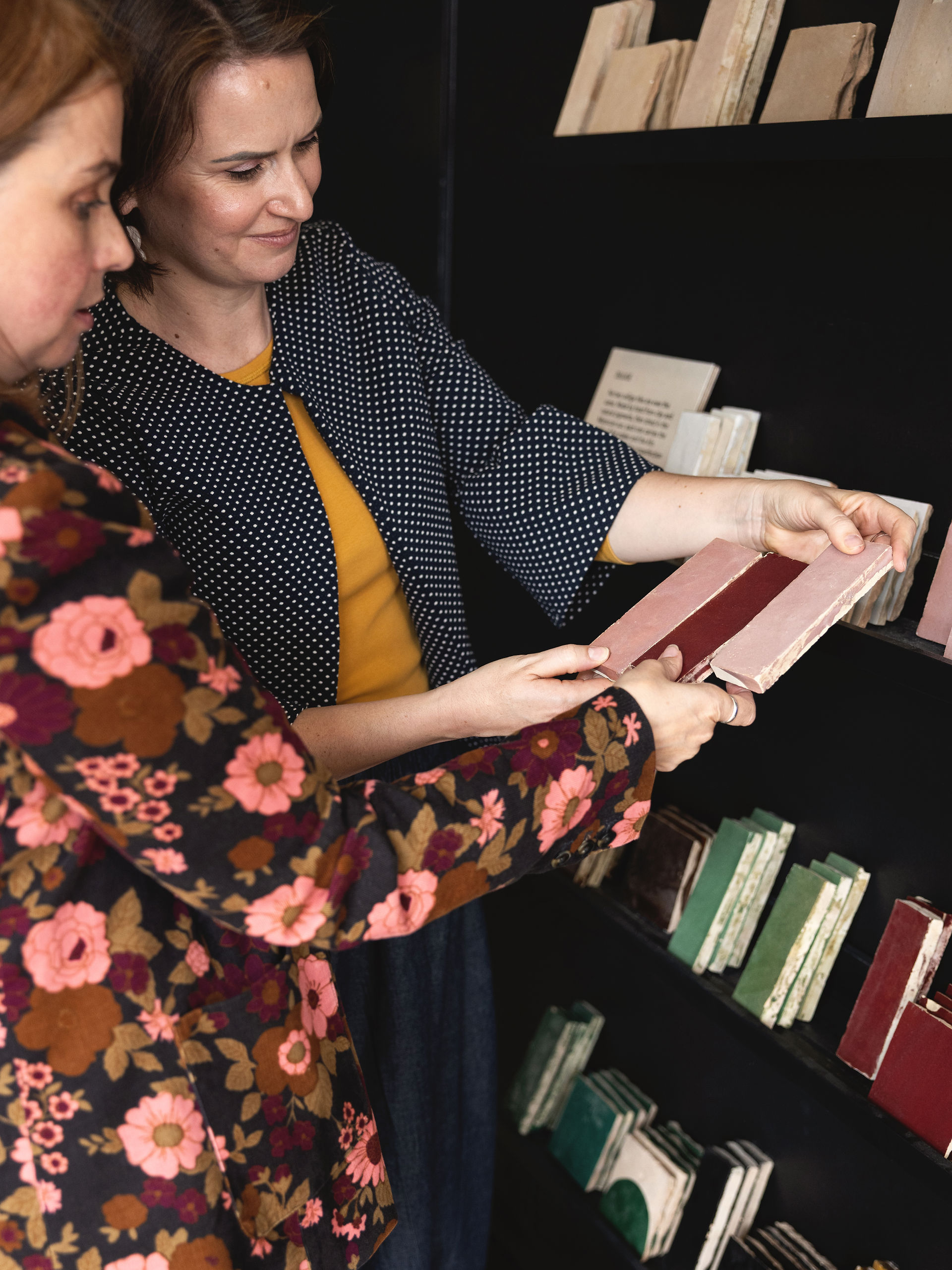 (woman in floral top selecting fabric swatches): Interior designer Hannah Redden selecting fabric sw
