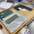 Interior design sample board created during the Bristol Folk House interiors course. A wooden tray displays fabric swatches, paint chips, and material samples curated for a home design scheme.