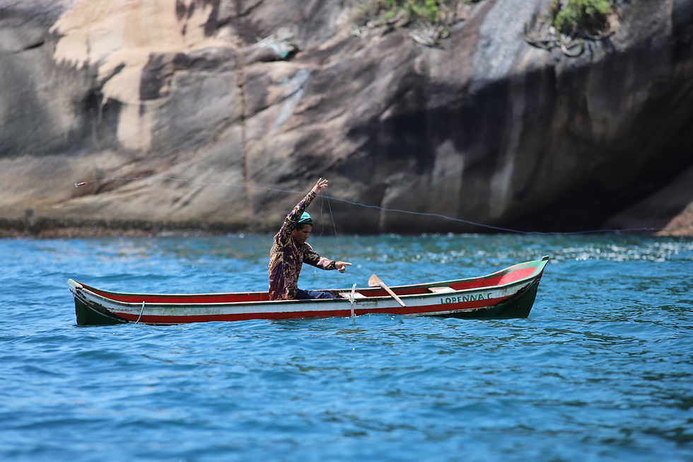 Imagem mostra um homem pescando em um barco, segurando uma linha de pesca no alto,