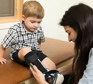 Cassandra-putting-on-orthotics.webp