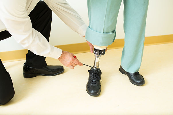 clinician working on the ankle joint of a patient's prosthetic leg