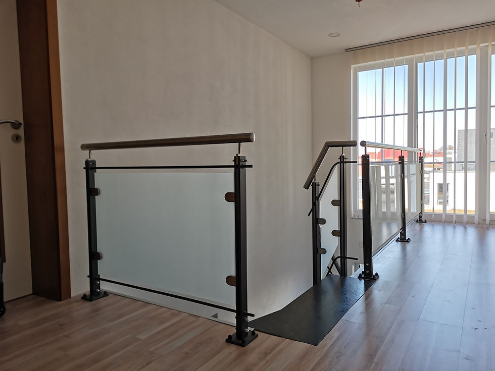 Modernes Innen-Glasgeländer mit dunklen Pfosten im Haus