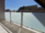 Balkon mit Glasgeländer aus Milchglas und Edelstahl.