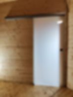 Ganzglas-Schiebetür aus Milchglas in Holzwand