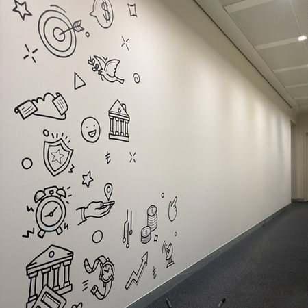 Architectural view showing the completed Doodlism wall mural illuminated by hallway lights in QNBpay’s 19th-floor office space.