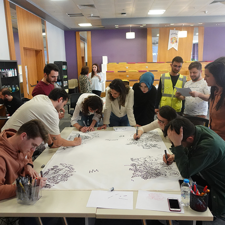 Close-up view of hand-drawn personal care motifs and continuous black lines created by workshop participants.