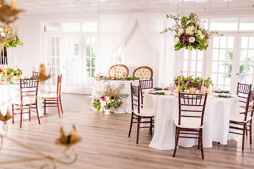 Venue 1824 Beautifully decorated reception hall with elegant table settings and warm lighting.