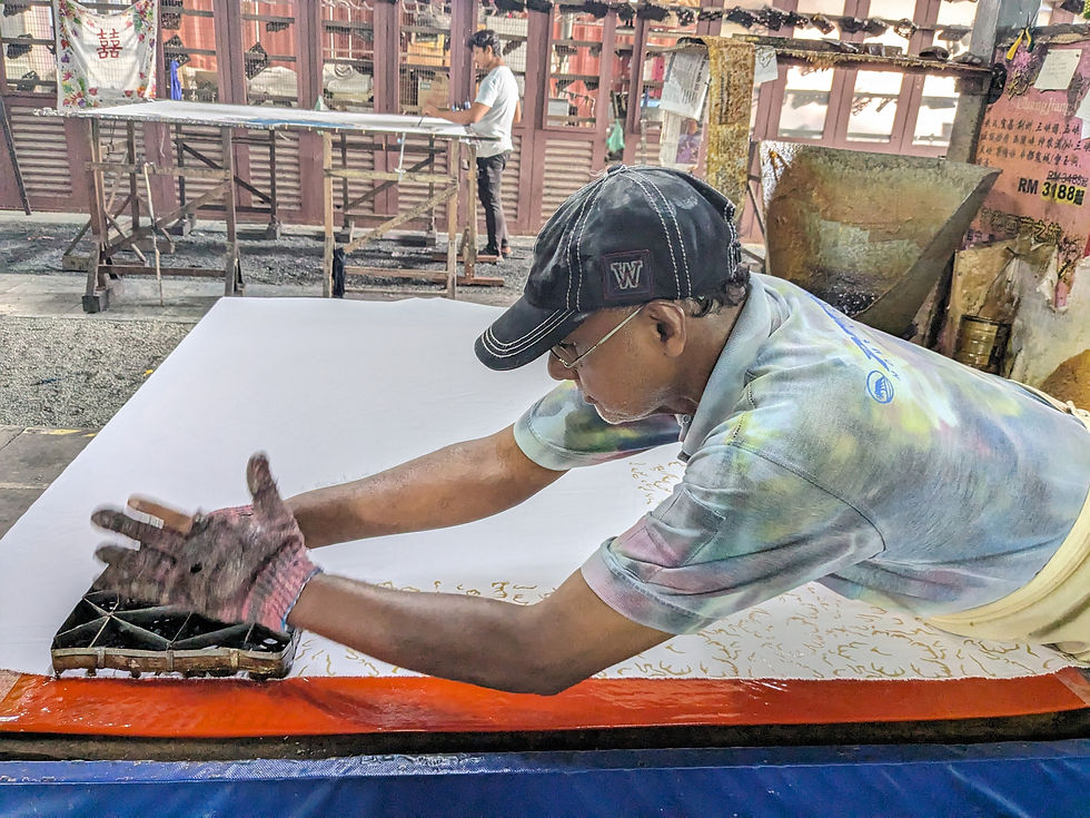 man handcrafting batik in penang