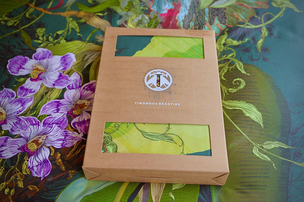 Eco-friendly boxed packaging for Timorous Beasties Tropical Botanical duvet set displayed on green velvet fabric at Carvills.