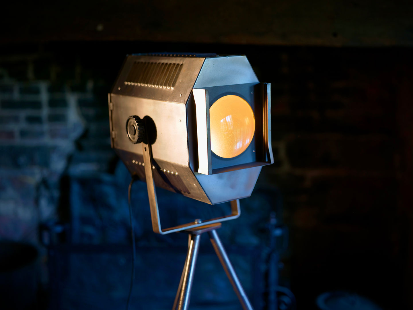 Vintage stage spotlight on a tripod in a dark room.