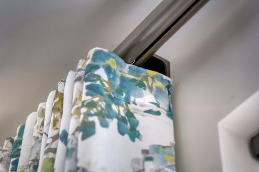 Elegant teal floral curtains hanging on modern rod