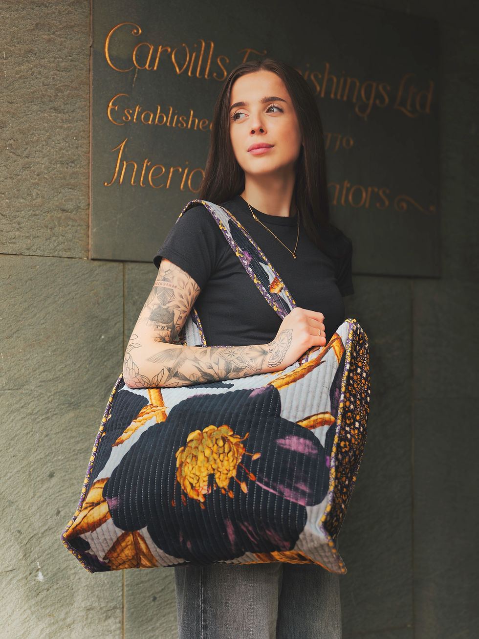 Grace outside Carvills Furnishings in Uckfield holding a large Powder quilted velvet tote bag with bold floral print.