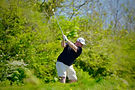 Action shot of James Zytynski mid-swing with a dense green woodland backdrop at Lewes Golf Club.