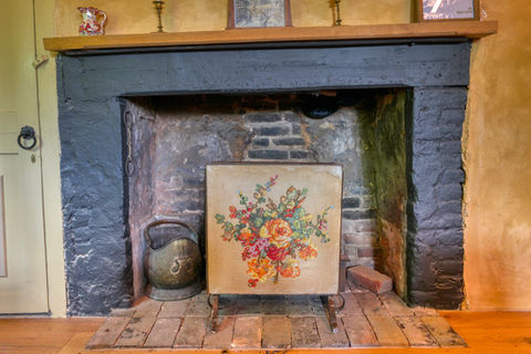 Floral fire screen in antique fireplace