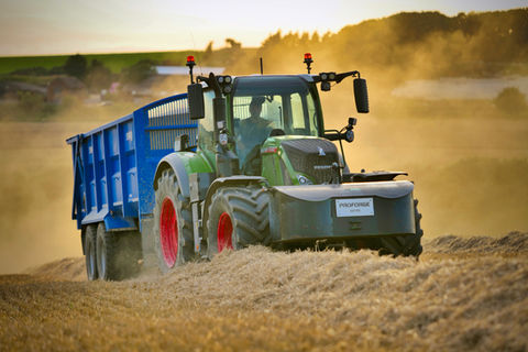 Tractor harvesting hay in field