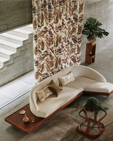 Cream sofa with patterned cushions and curtains