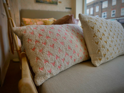Pink and gold patterned cushions on bed
