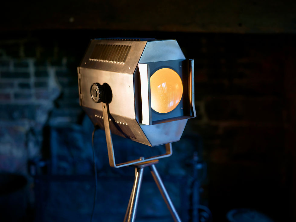 Vintage stage spotlight on a tripod in a dark room.