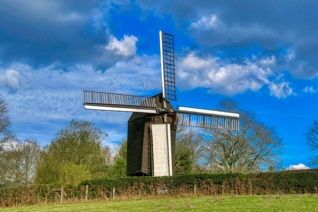 Windmill under a blue sky with clouds