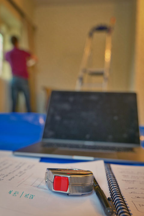 Measuring tape, blueprints, laptop; home renovation