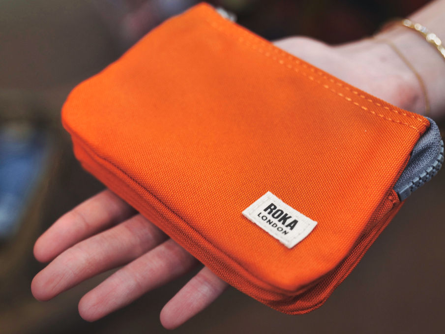 Orange Rokka London pouch held in hand