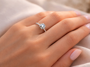 Oval diamond engagement ring on left hand with yellow gold band