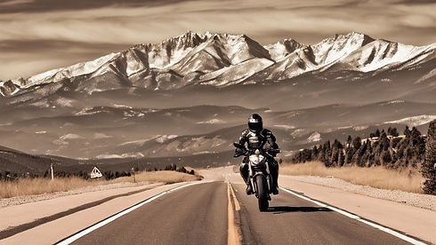 the pikes peak mountain range with a road weaving up the mountain with a brown ducati mons...ted.jpg