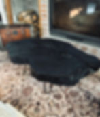 Mesa de centro negra con patas de metal sobre una alfombra Tierra Del Cipres