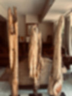 Tres totems de madera en interior. Totems de Ciprés, detalles del entorno.